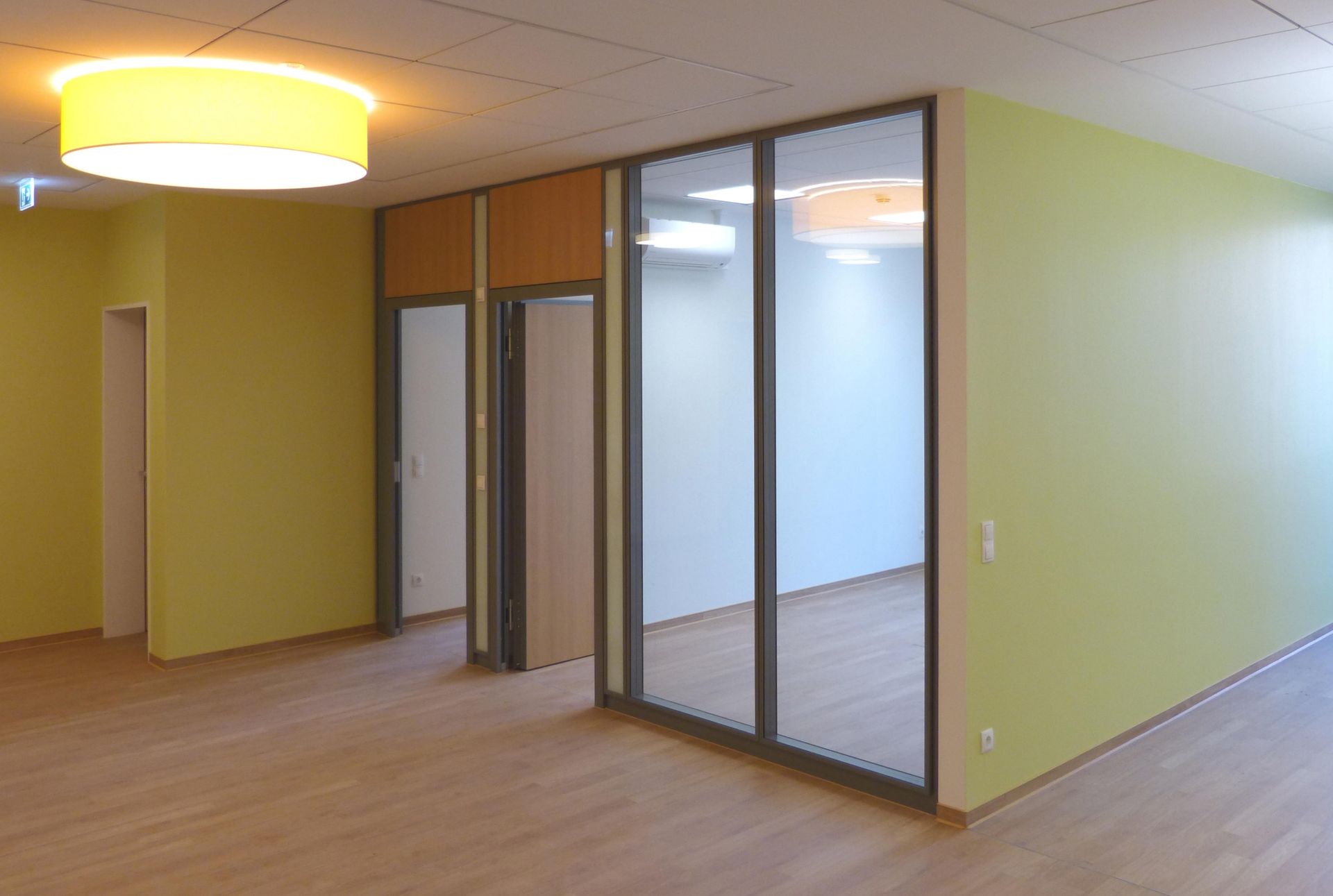 Ein leerer Raum mit gelben Wänden und Holzboden.