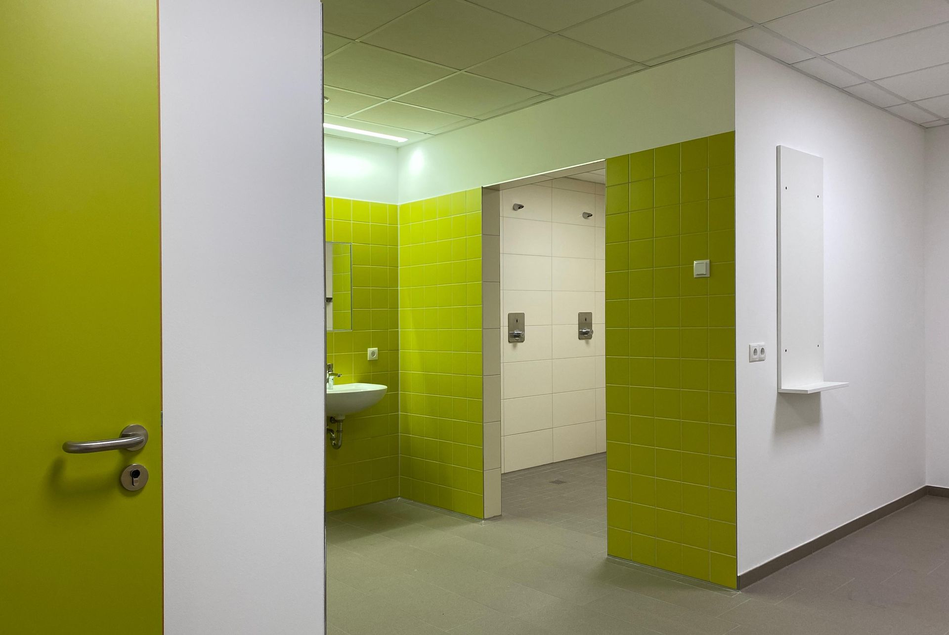 Ein Flur mit einem Waschbecken und Schließfächern in einem Gebäude.