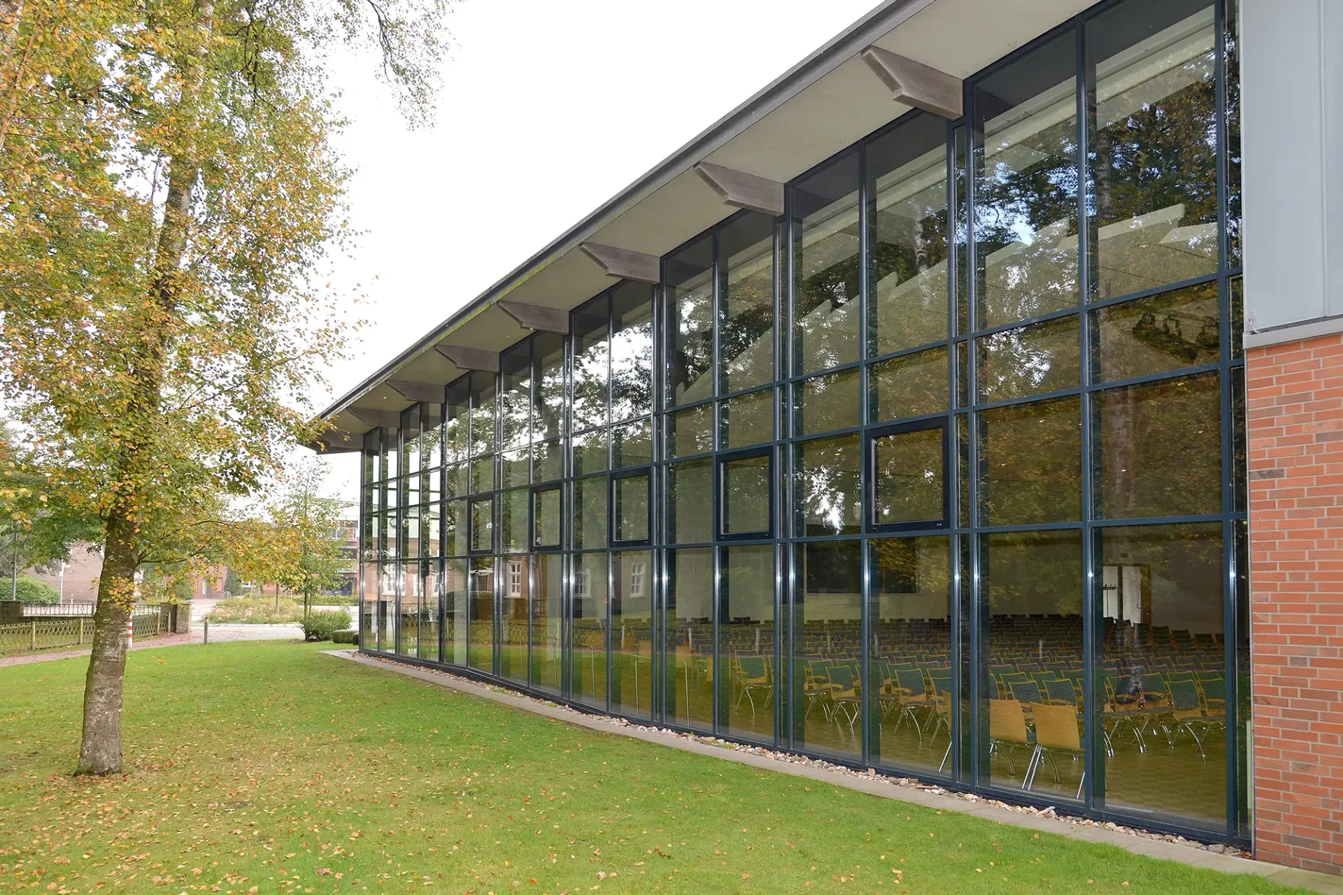 Ein großes Gebäude mit vielen Fenstern und einem Baum davor