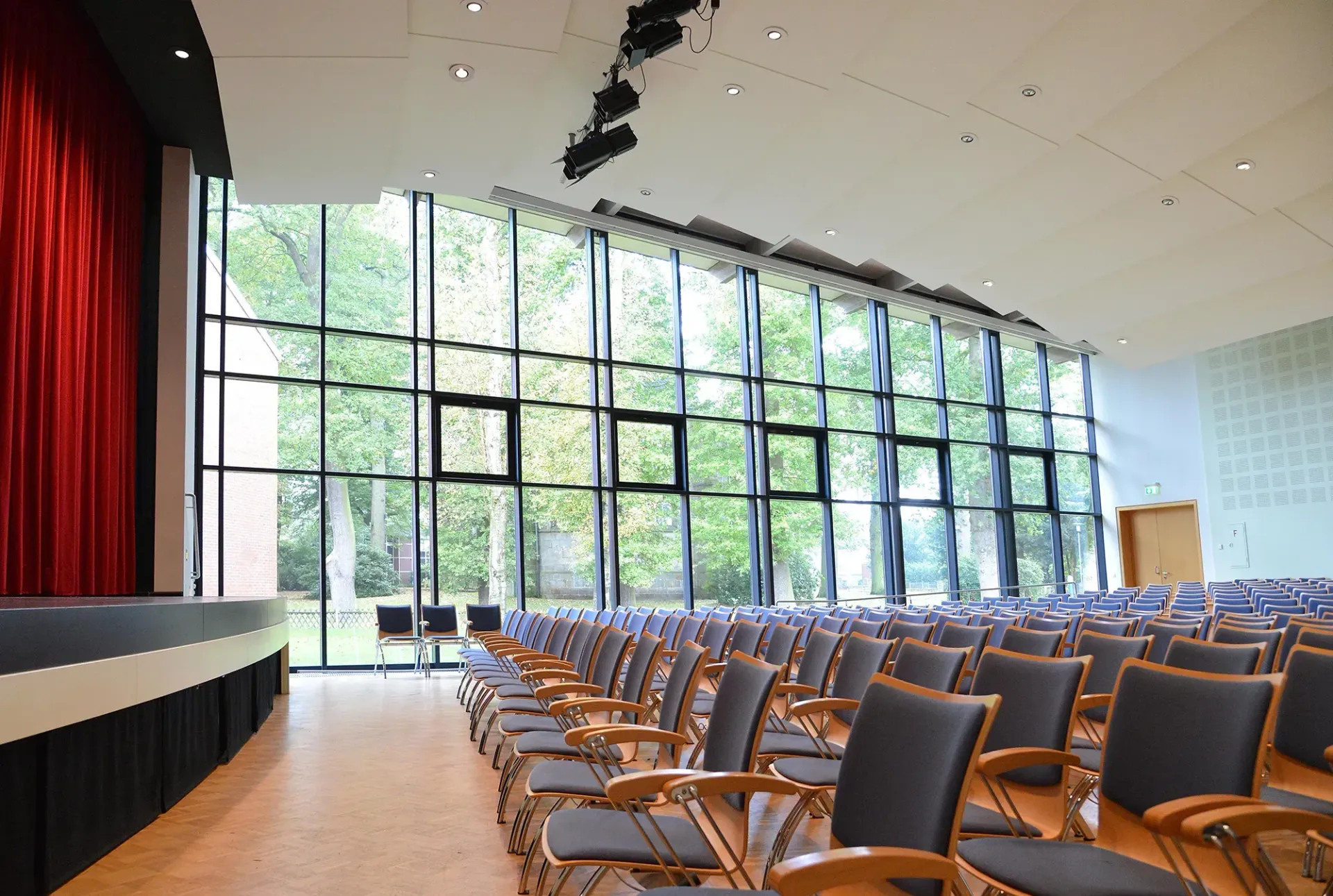 Ein großer Zuschauerraum mit Stuhlreihen und einer Bühne.