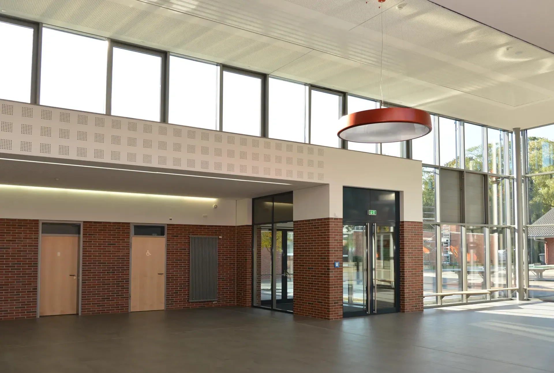 Ein großer Raum mit vielen Fenstern und Türen