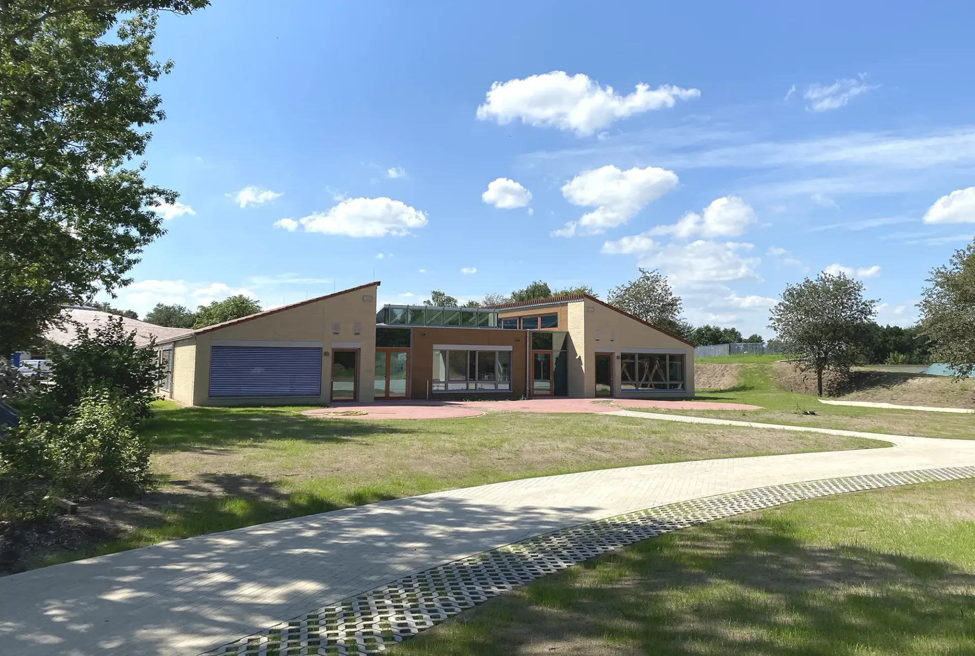 Ein Haus mit einer blau-weißen Flagge an der Seite ist von Gras und Bäumen umgeben.