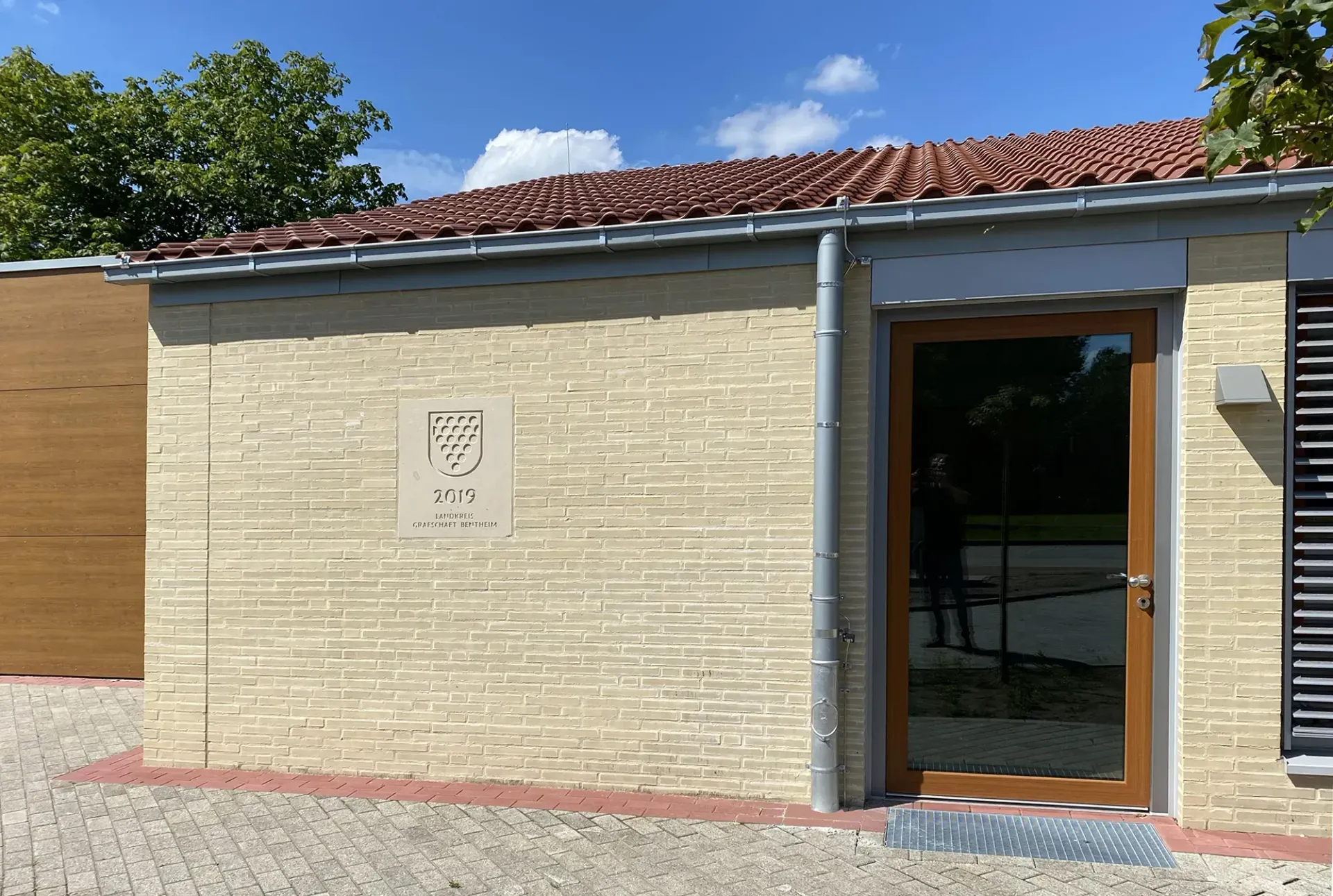 Ein Backsteingebäude mit einer Holztür und einem Schild an der Seite.