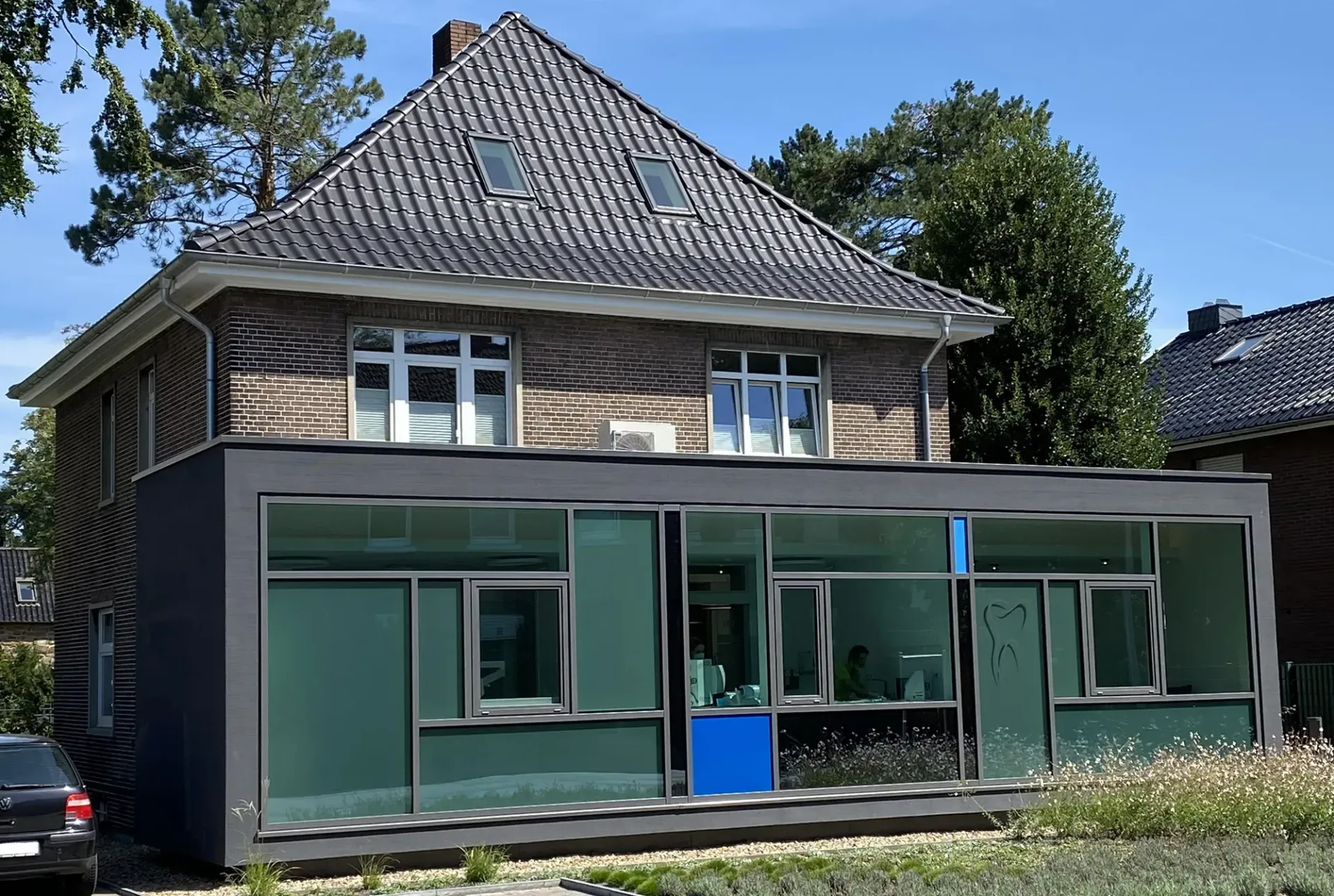 Ein Haus mit vielen Fenstern und einer blauen Tür