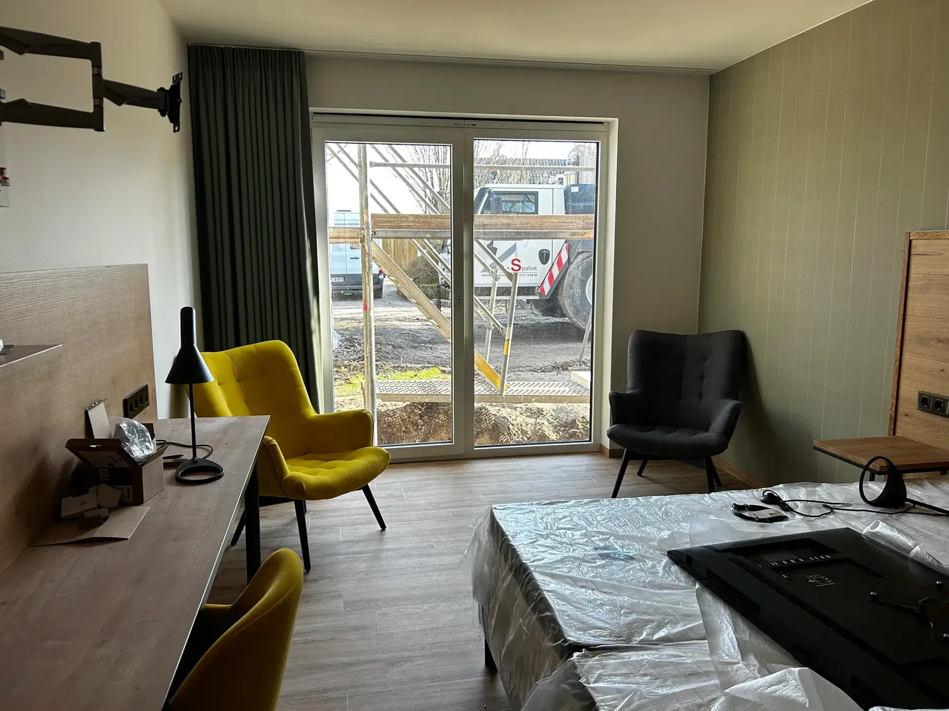 Ein Hotelzimmer mit Bett, Stühlen, Schreibtisch und Fernseher.