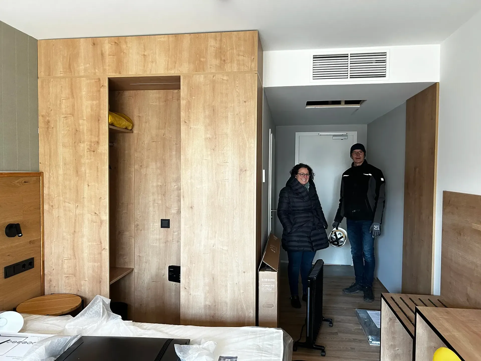 Ein Mann und eine Frau stehen in einem Hotelzimmer.