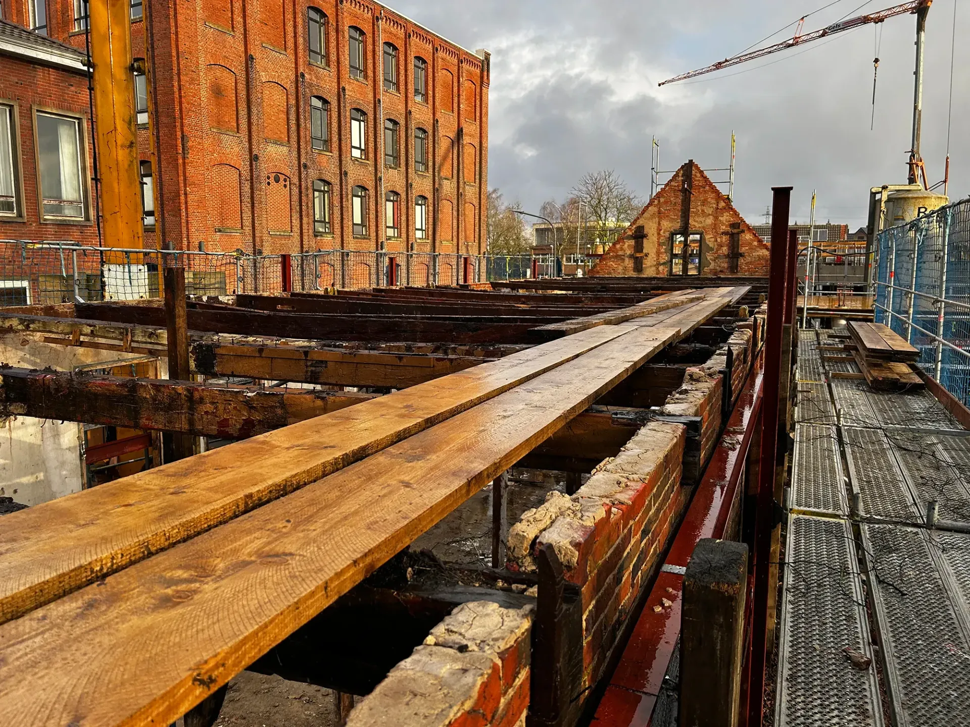 Eine Baustelle mit einem Backsteingebäude im Hintergrund