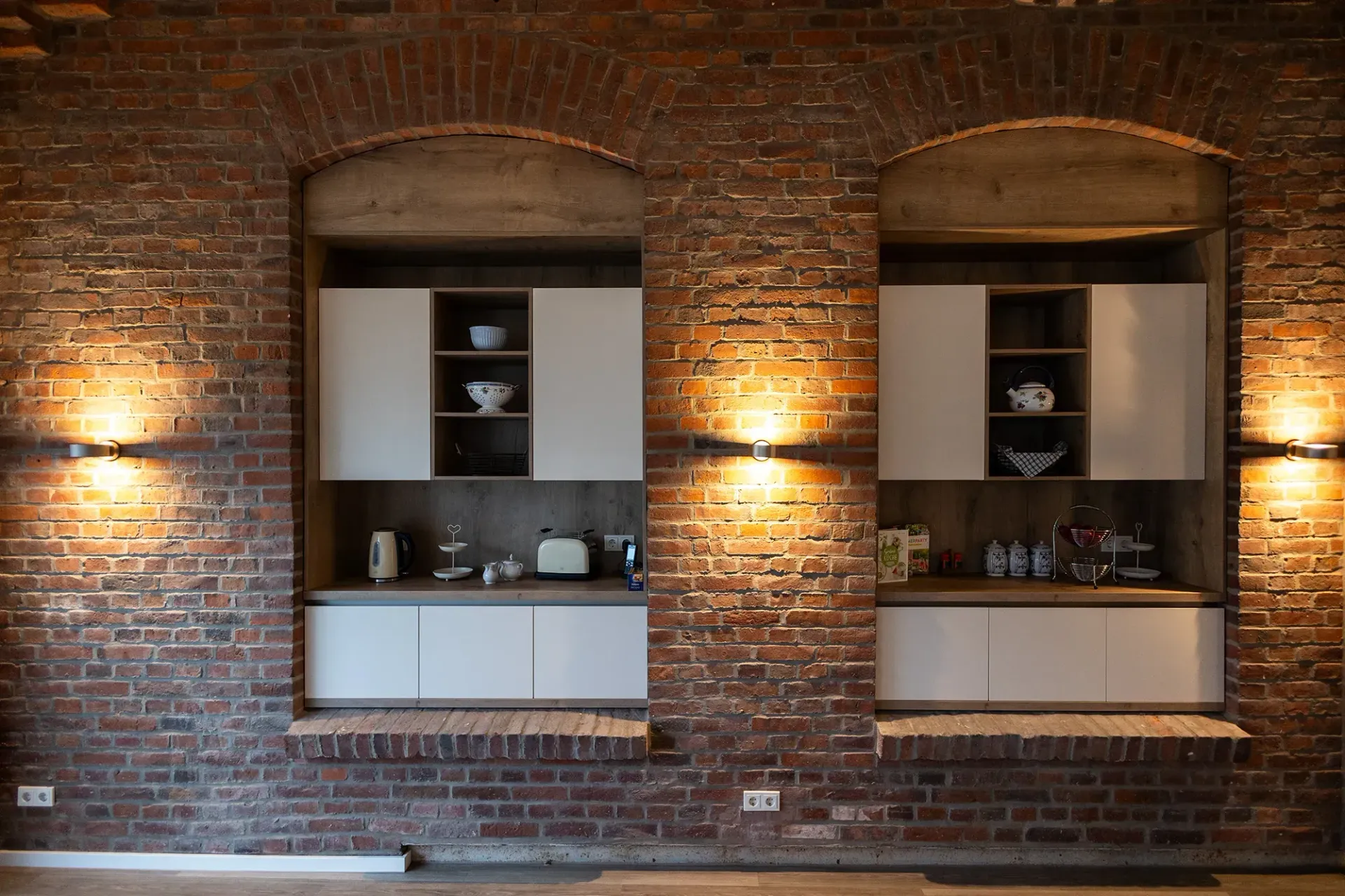 Eine Küche mit Backsteinwand und weißen Schränken