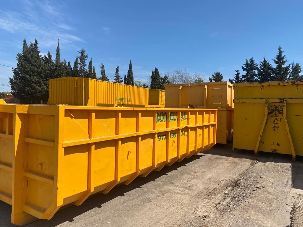 Un montón de contenedores amarillos están alineados en un estacionamiento.