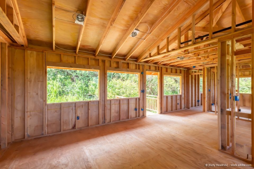 Ein leerer Raum in einem im Bau befindlichen Haus mit Holzwänden und Fenstern