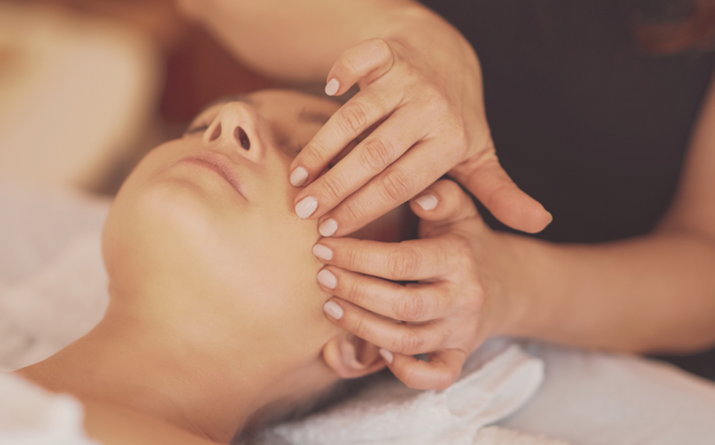 Personne recevant un massage facial.
