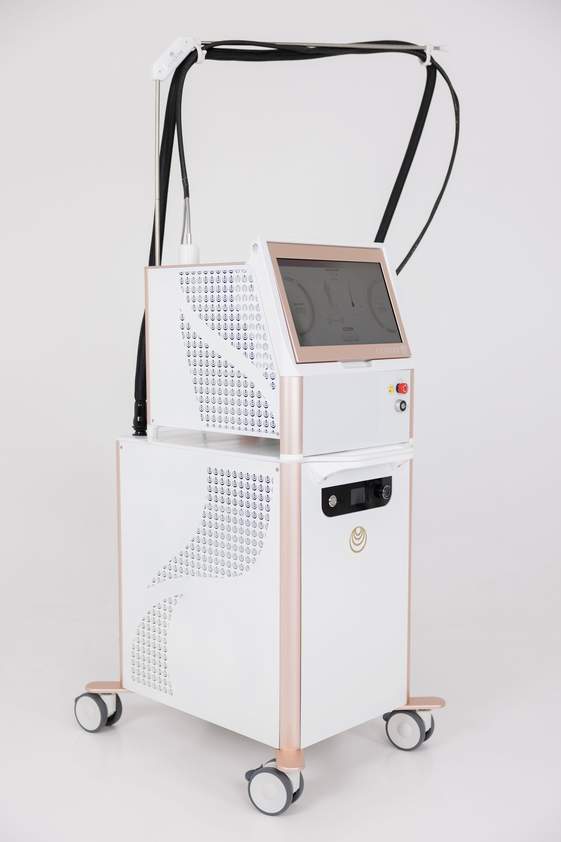 Dispositif médical sur roulettes, blanc et or rose, avec écran tactile et câbles noirs.