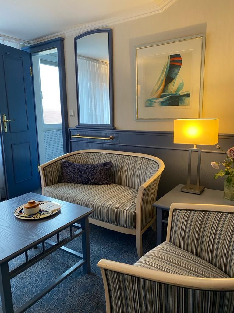 Ein Wohnzimmer mit einer Sitzbank, Sessel, einem Couchtisch und einer Lampe.