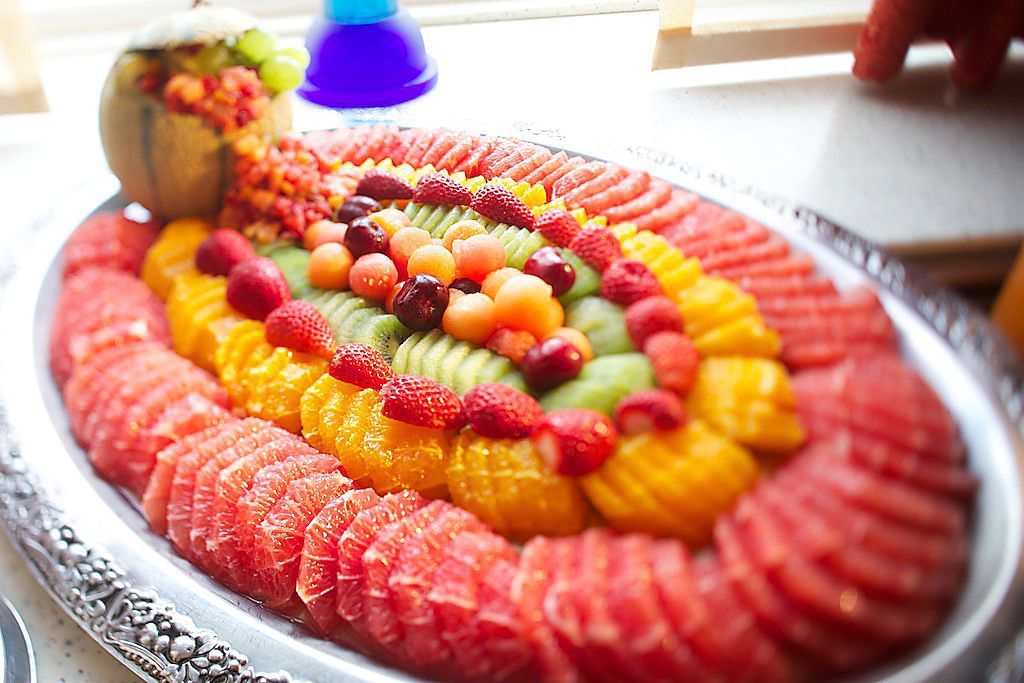 Auf einem Tisch steht ein Tablett mit geschnittenem Obst.