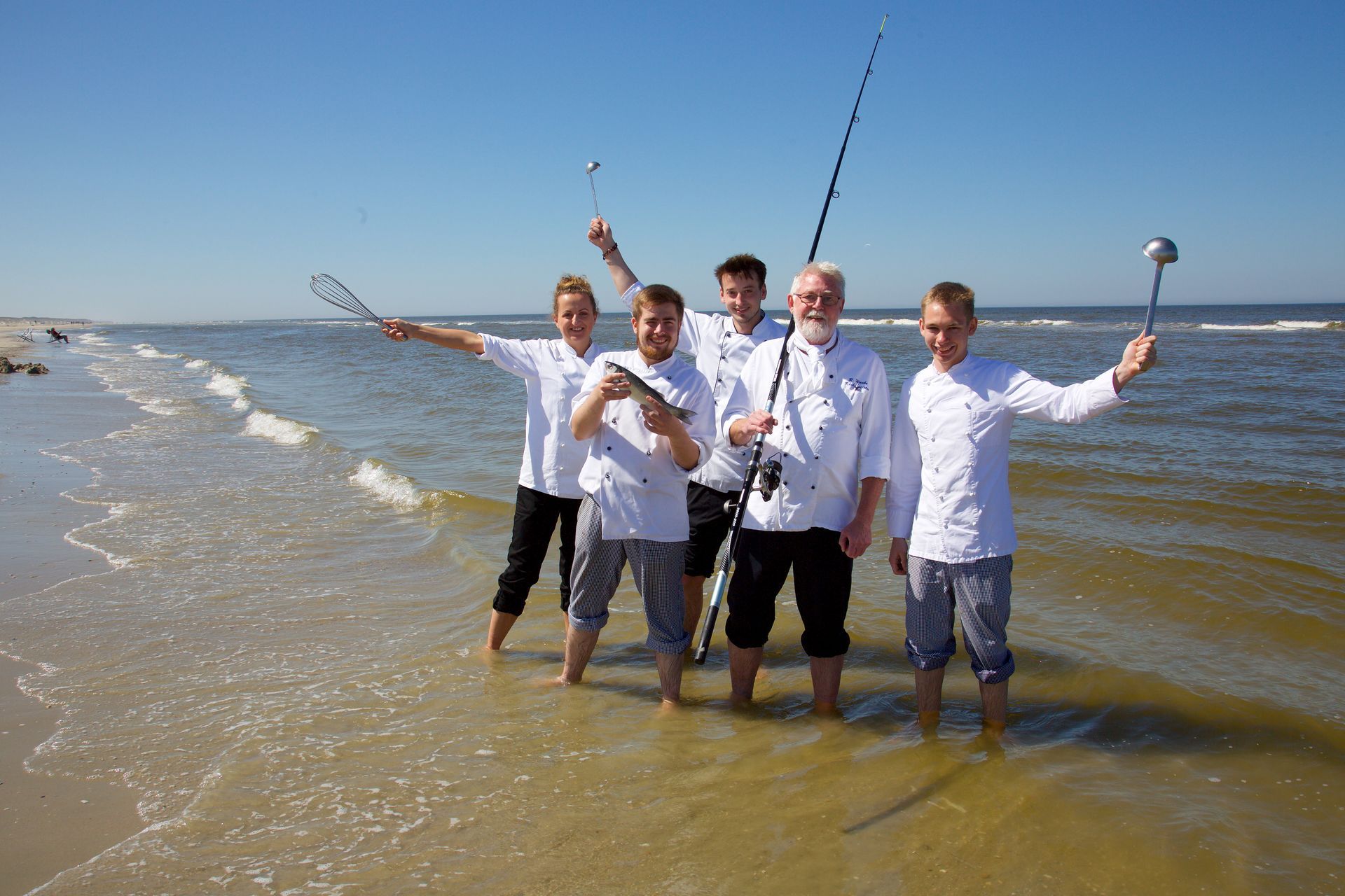 Eine Gruppe von Männern, die mit Angelruten im Wasser stehen