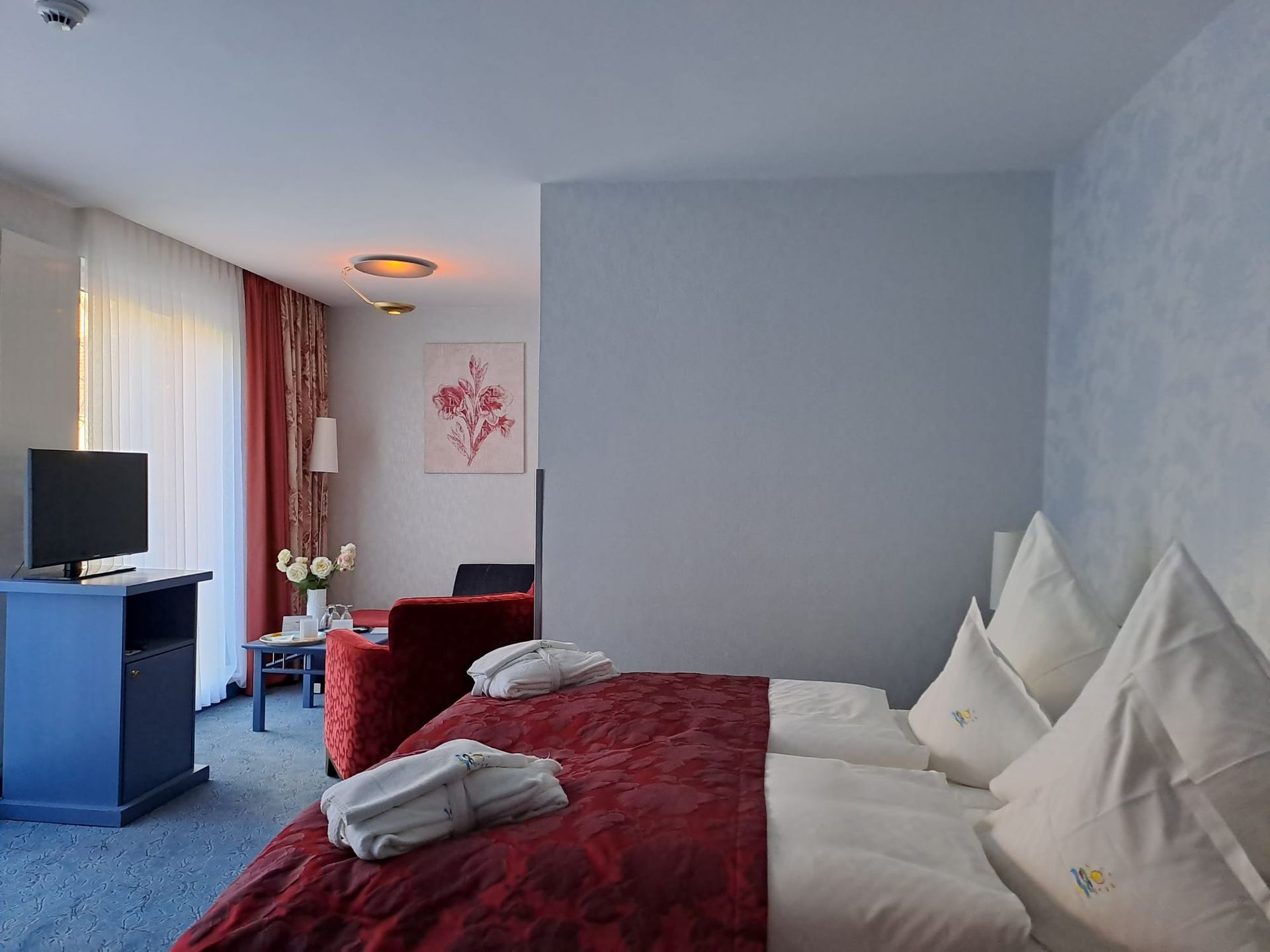 Ein Hotelzimmer mit einem Bett und einem Fernseher sowie Sitzecke.