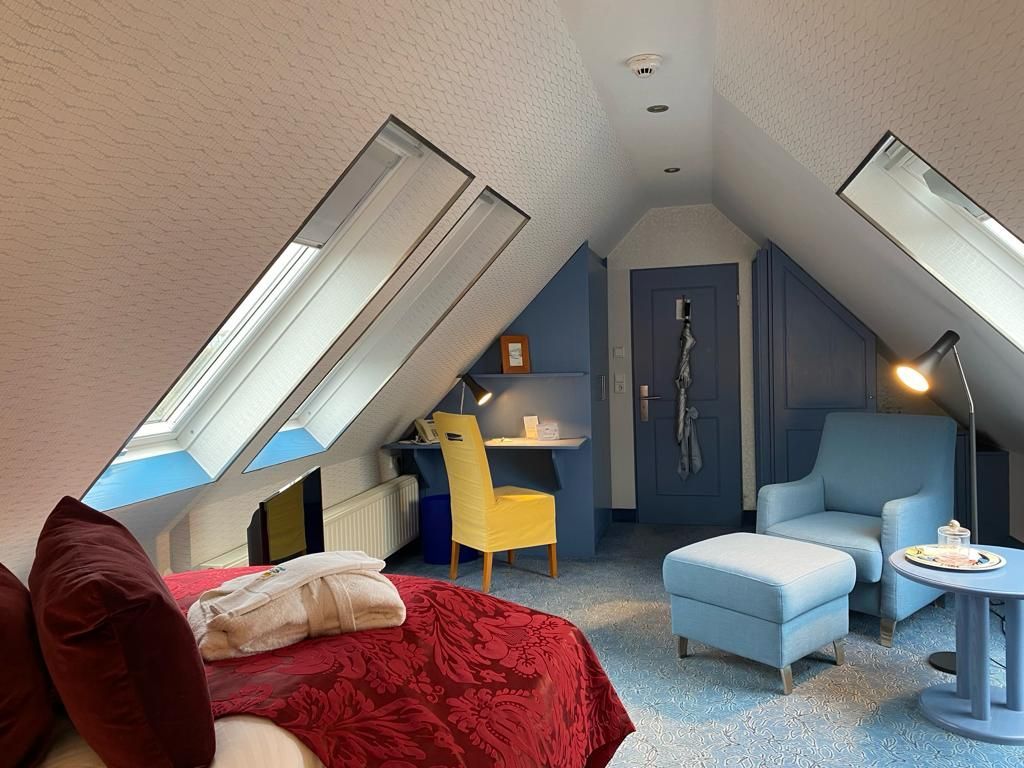 Ein Schlafzimmer mit einem Bett, Stühlen, Hockern und einem Tisch