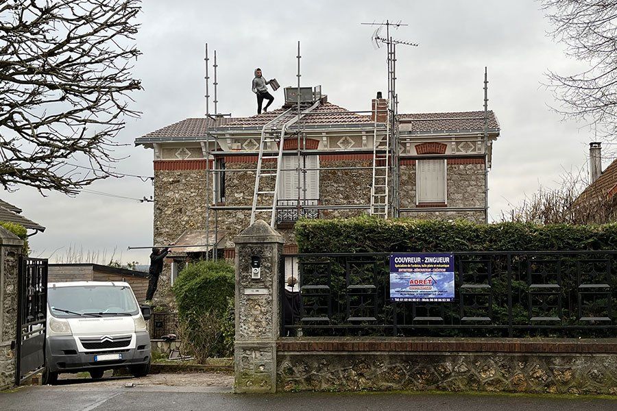 Un artisan qui travaille sur la toiture d'une maison