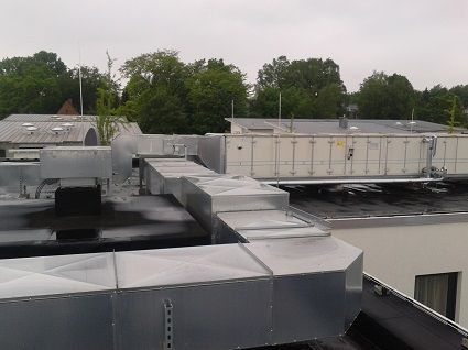 Verzinkte Metall-Lüftungskanäle sind auf dem Dach eines Flachgebäudes installiert.