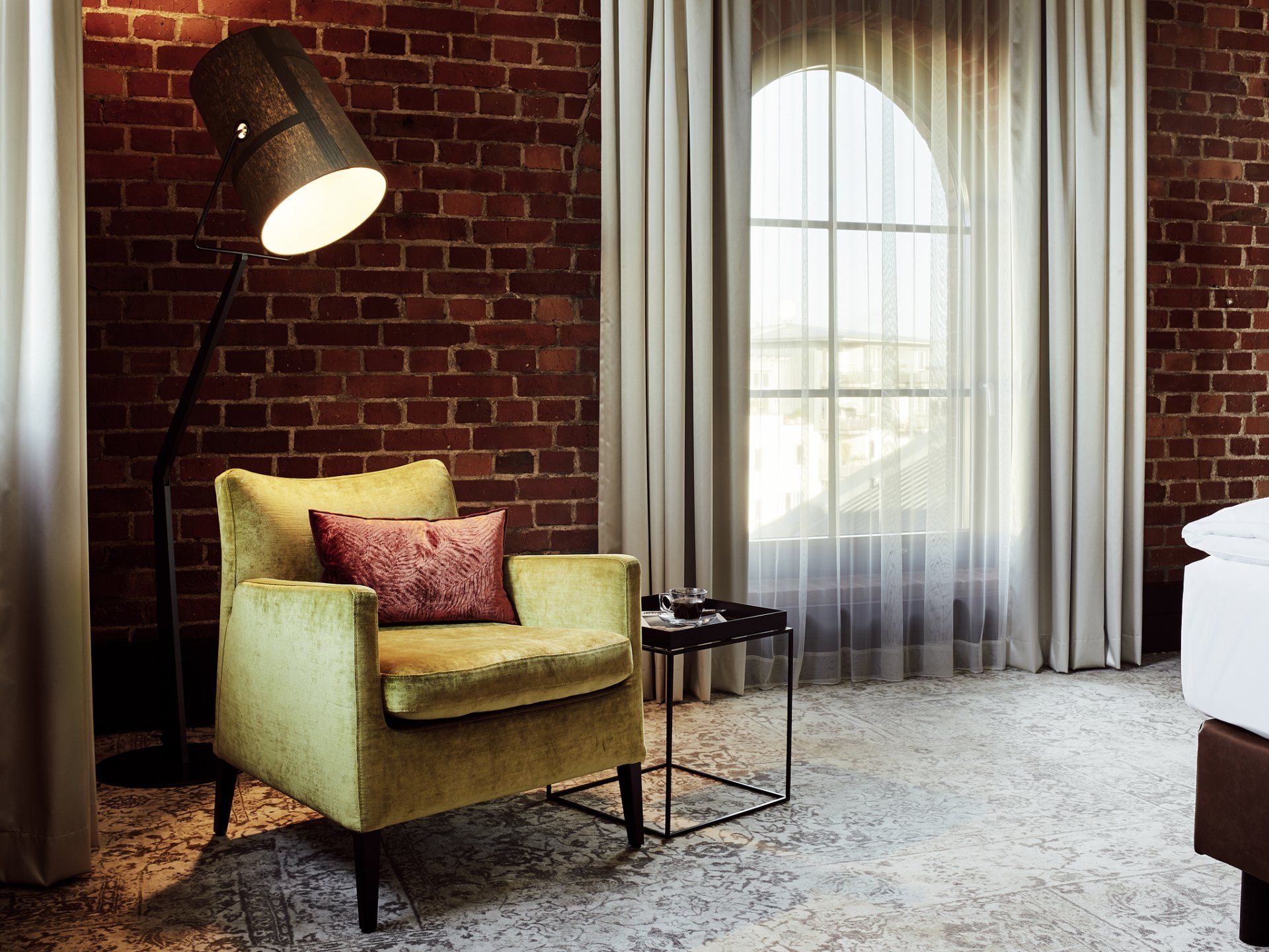 Gelber Sessel vor Backsteinwand im L-Loft im Gastwerk Hotel