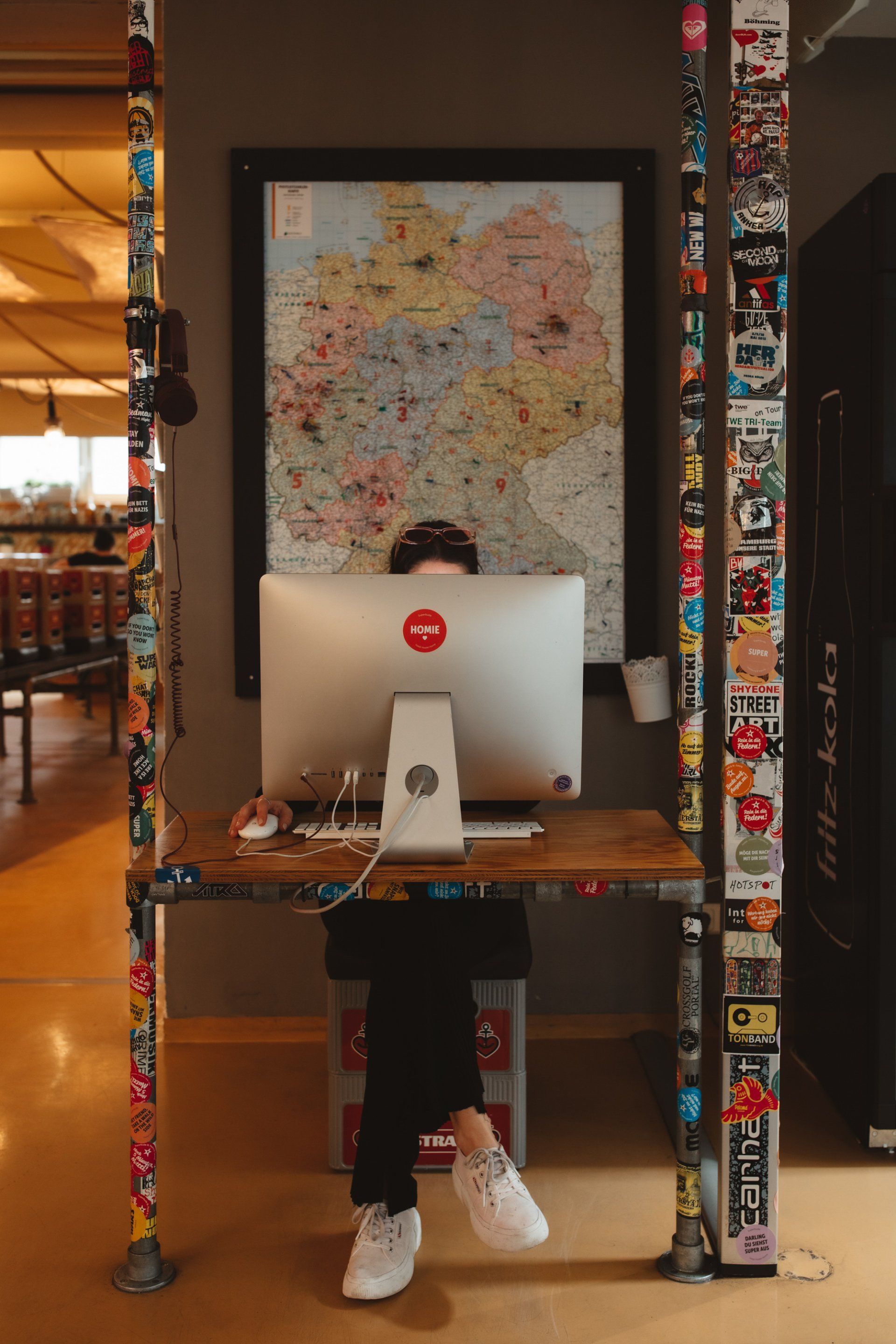 Person sitzt hinter einem großen Computer Bildschirm