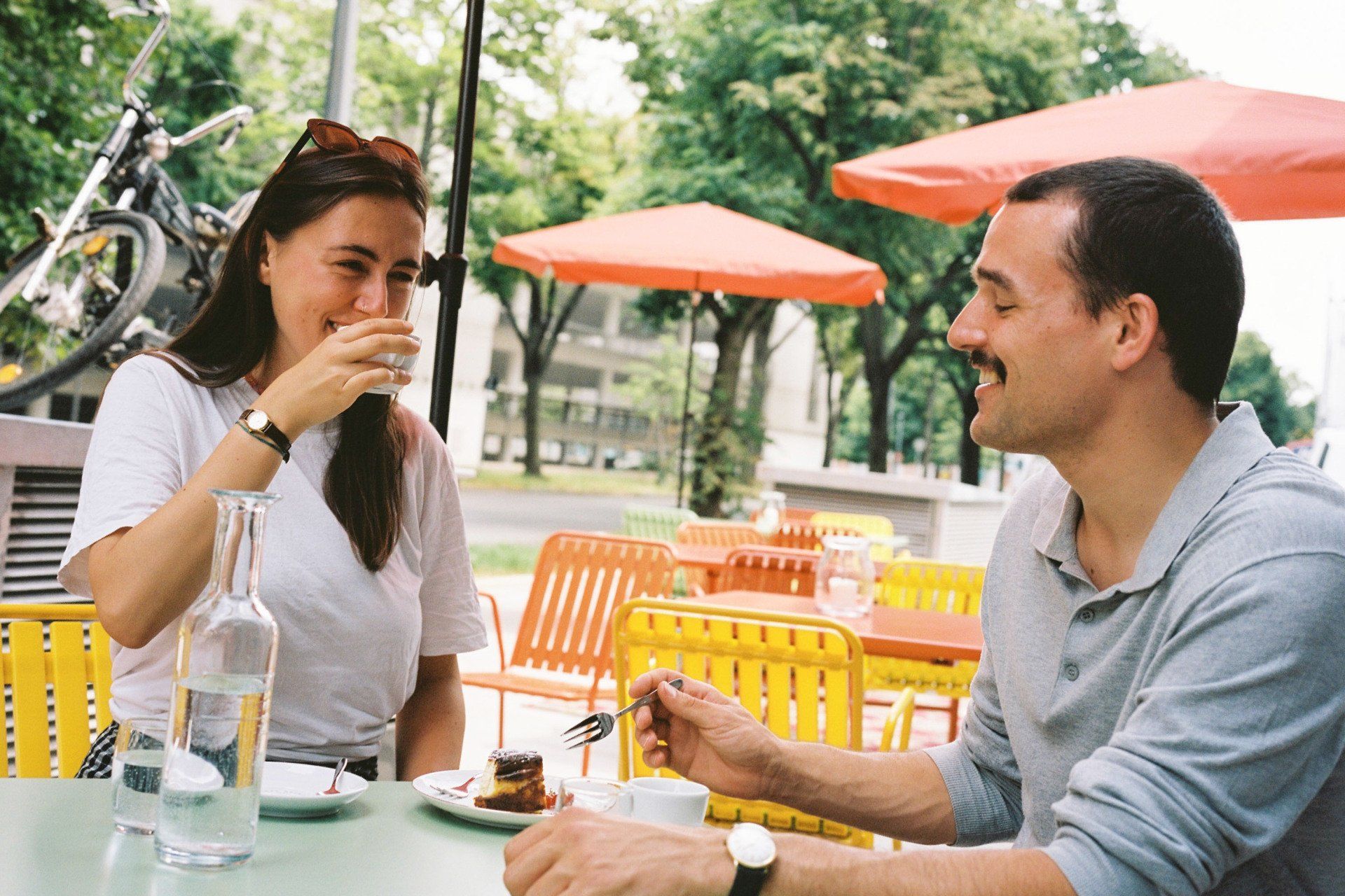 Zwei Personen trinken Kaffee und essen Kuchen im Außenbereich