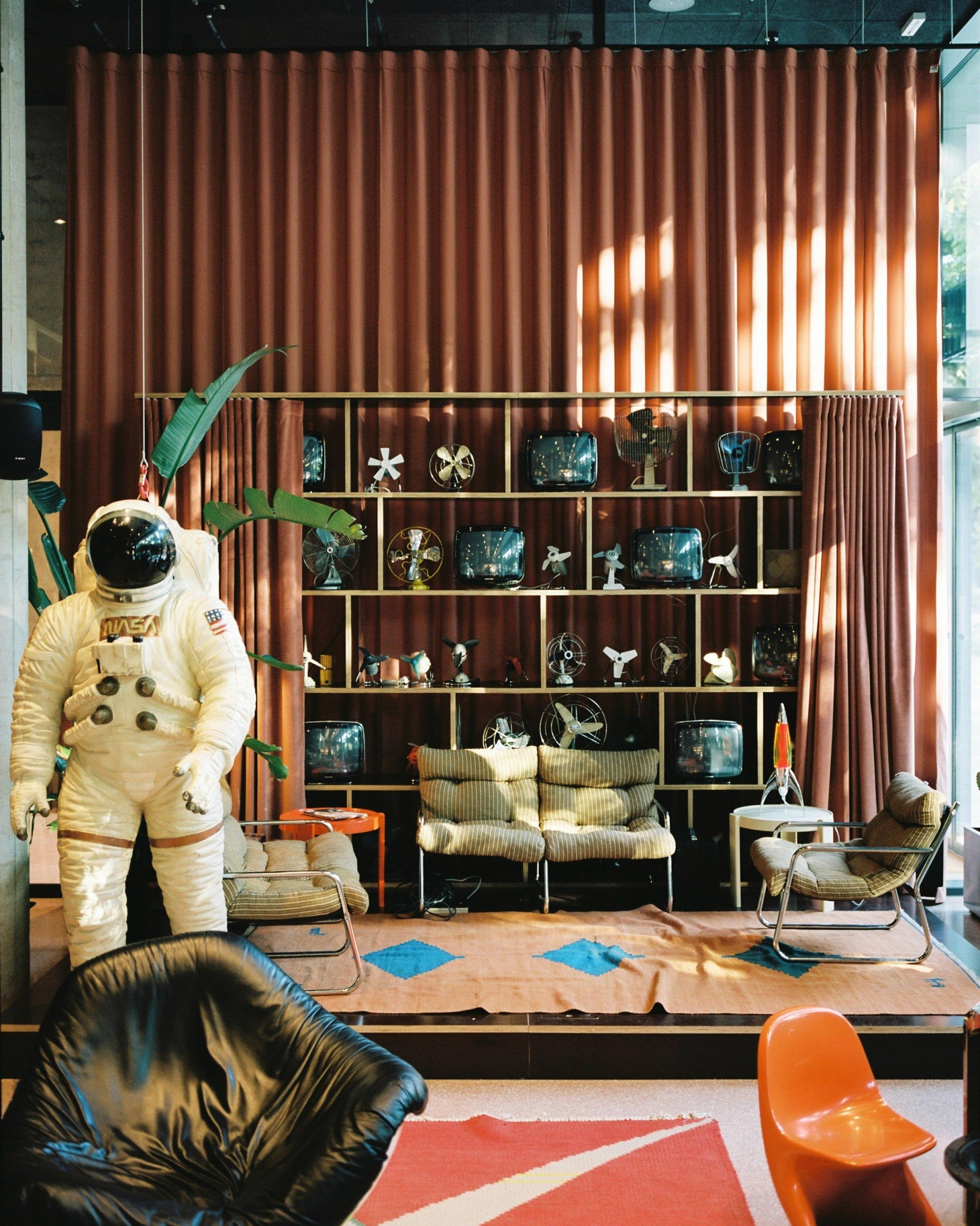 Dekorativer Astronaut vor Holzregal in der stilvollen Lobby der Superbude