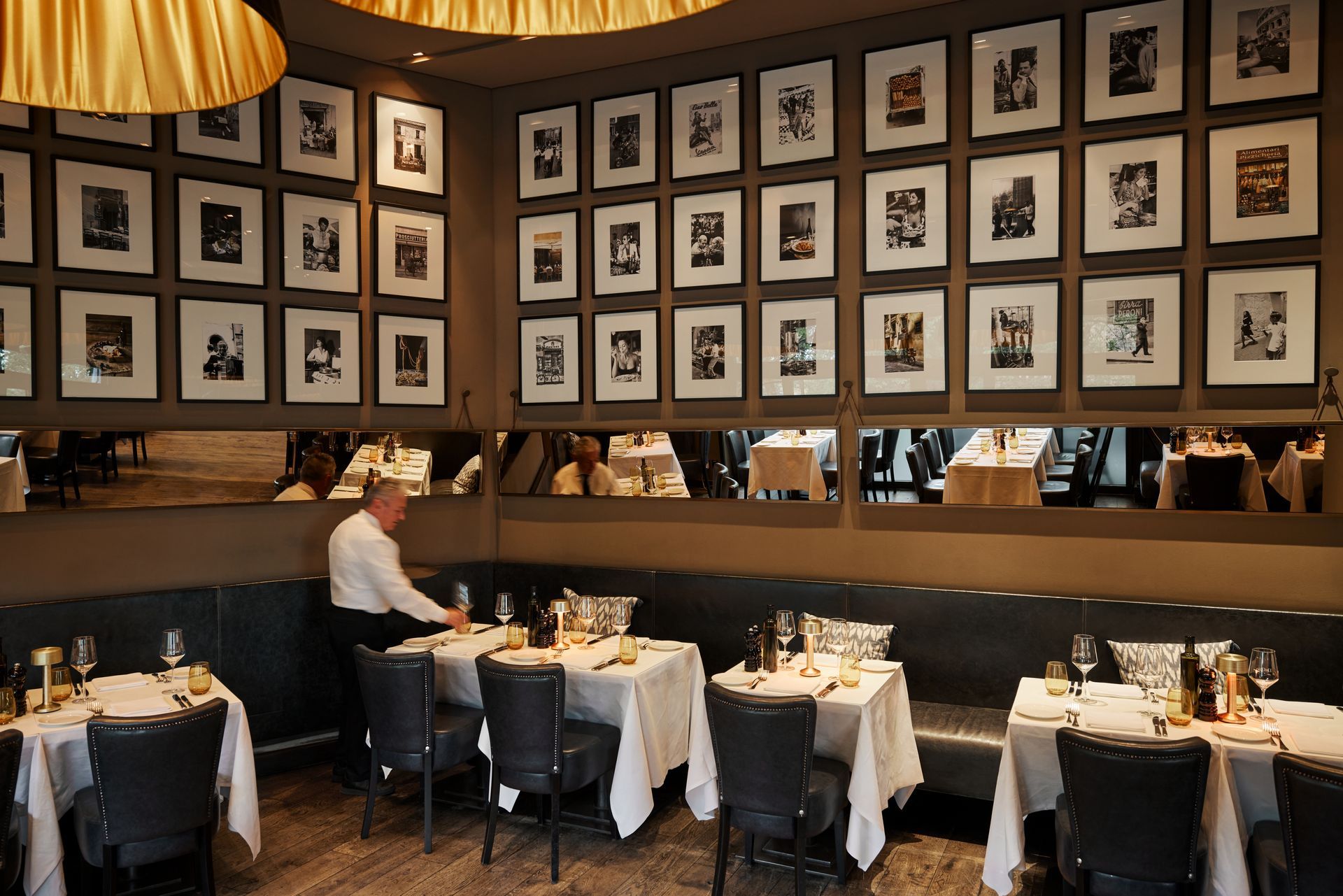 Eingedeckte Tische darüber eine Fotowand im Restaurant DaCaio