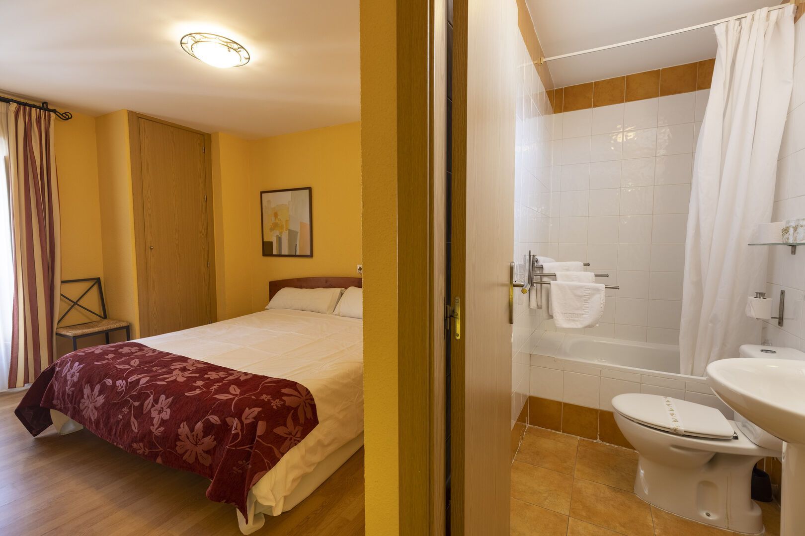 Un dormitorio con una cama y un baño con WC.