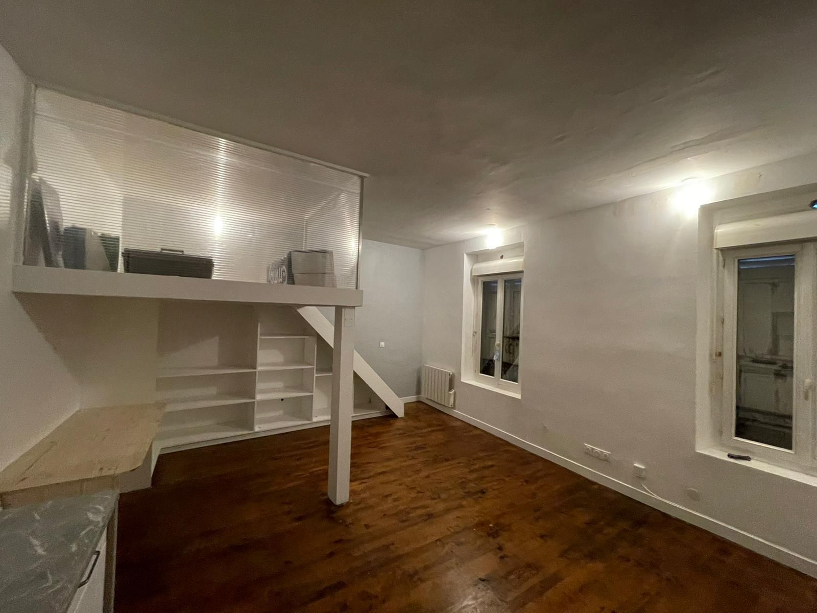 Pièce vide de style loft avec murs, parquet et lit mezzanine ou balustrade de mezzanine.