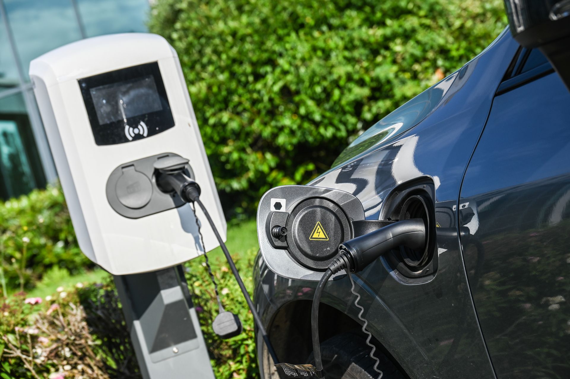 Voiture électrique en charge à une borne de recharge publique extérieure.