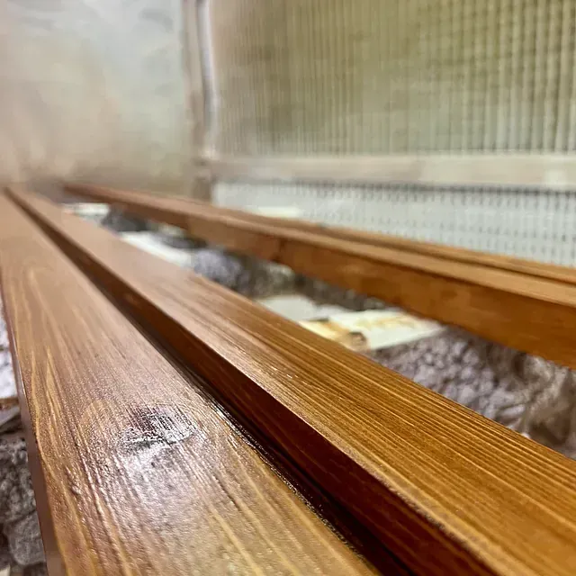 Un primer plano de una barandilla de madera con un fondo borroso.