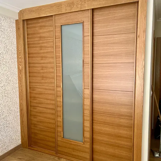 Una puerta corrediza de madera con una ventana de vidrio en una habitación.