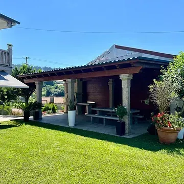 Una casa con un porche y una mesa de picnic en el patio trasero.