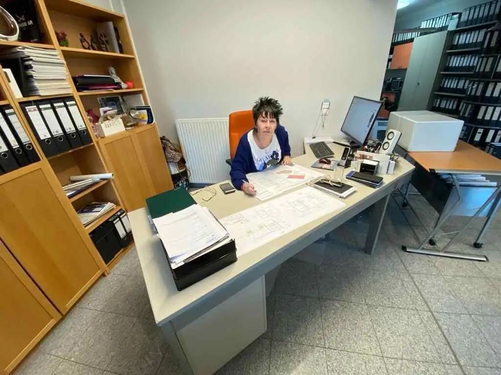 Eine Frau sitzt an einem Schreibtisch vor einem Computer.
