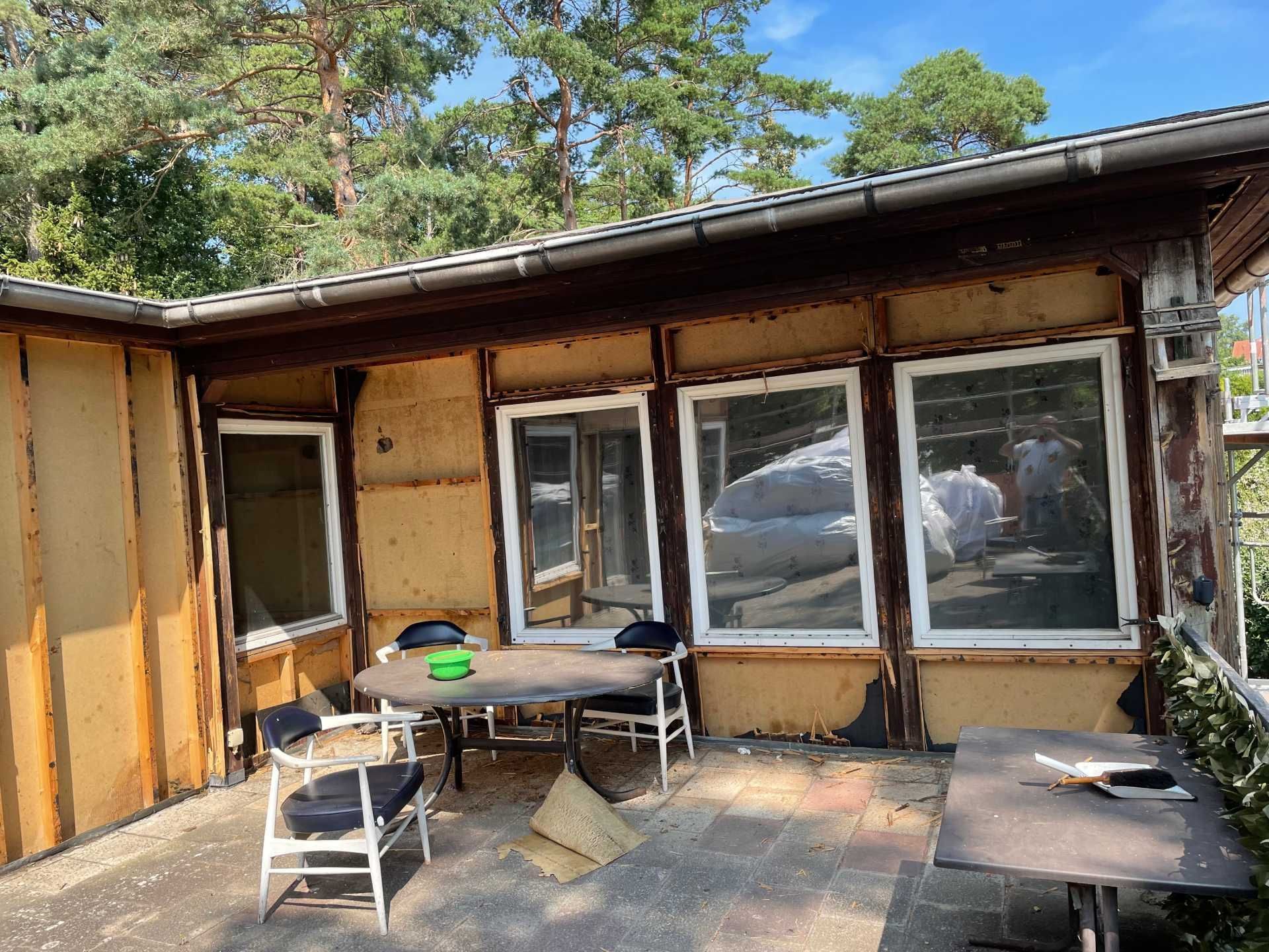 Ein Holzhaus mit einem Tisch und Stühlen davor.