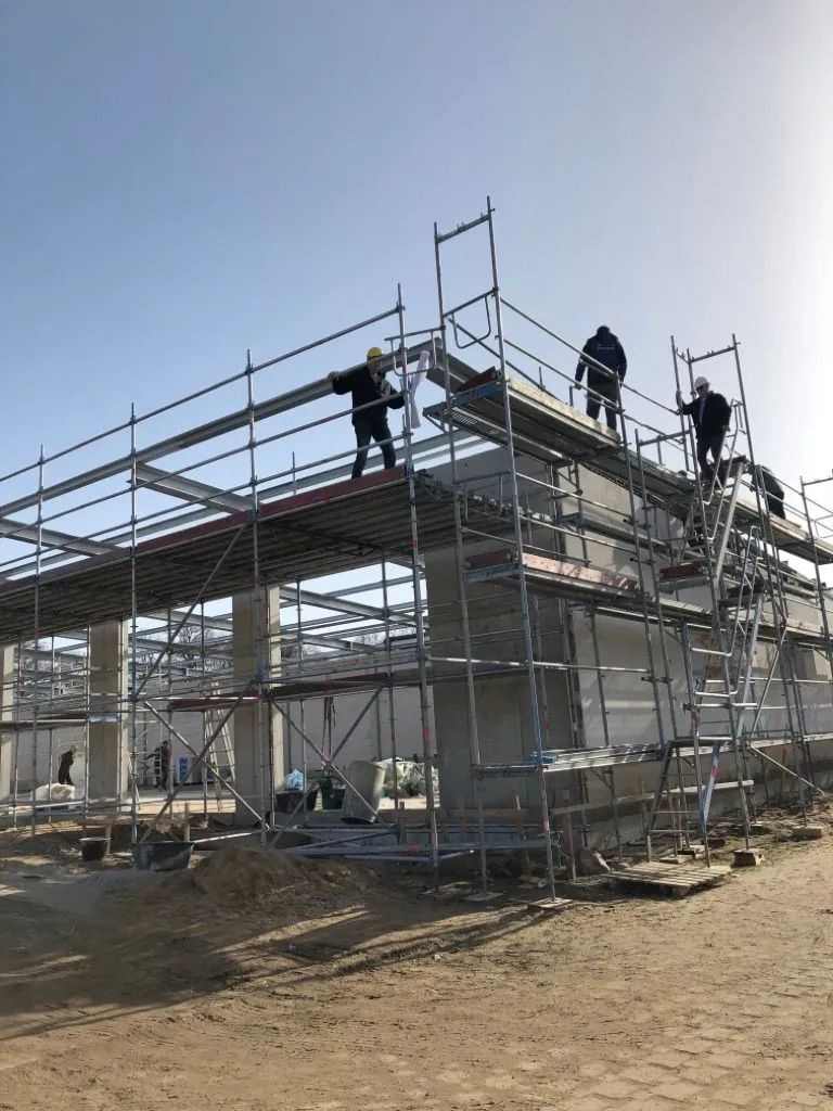 Eine Gruppe Bauarbeiter arbeitet an einer im Bau befindlichen Brücke.