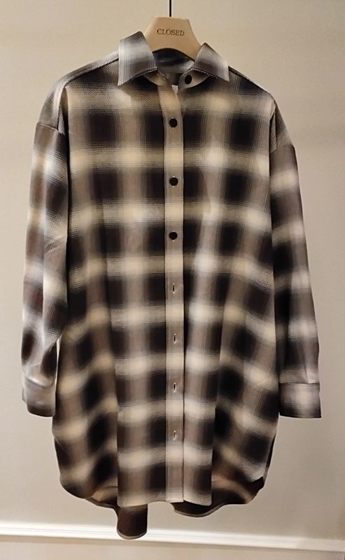 Übergroßes kariertes Hemd in Schwarz, Grau und Weiß, hängt auf einem Kleiderbügel.