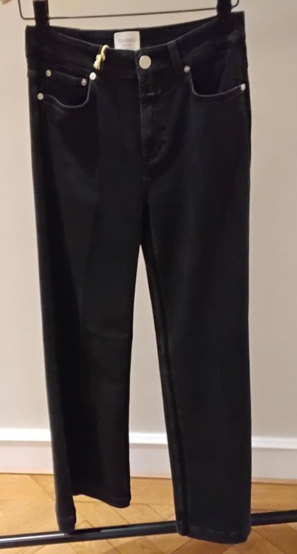 Schwarze Jeans hängen an einem Kleiderständer.