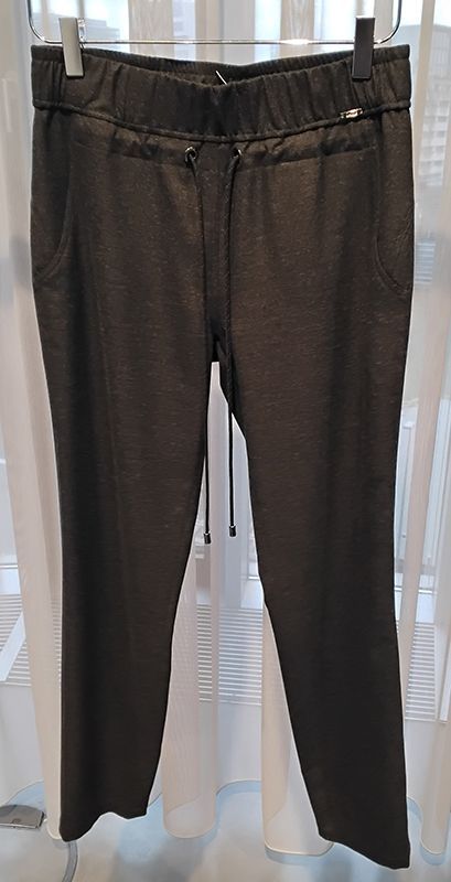 Graue Damen-Jogginghose mit Kordelzug, auf einem Ständer vor einem weißen Vorhang aufgehängt.