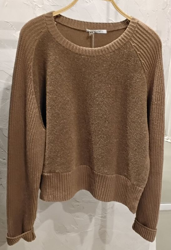 Brauner Rundhalspullover auf einem Kleiderbügel.