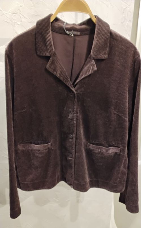 Brauner Samtblazer mit zwei Vordertaschen, hängt an einem Holzkleiderbügel.