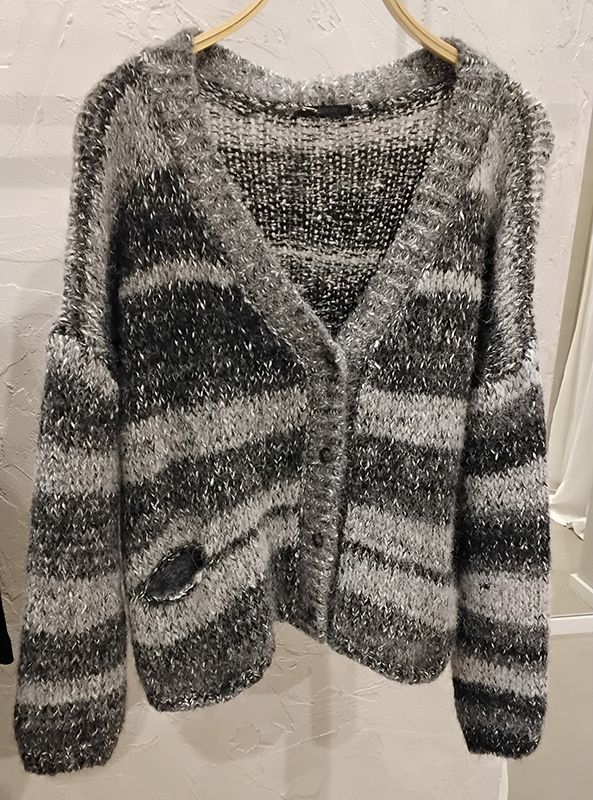 Grau-schwarz gestreifter Cardigan mit Knöpfen und Paillettenverzierungen, hängt an einem Holzkleiderbügel.