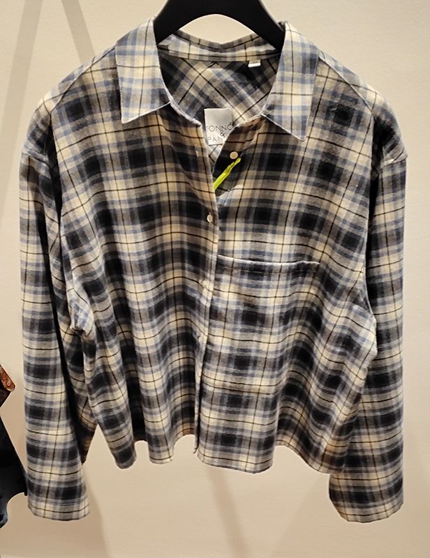 Schwarz-beiges kariertes Button-Down-Hemd auf einem Kleiderbügel.