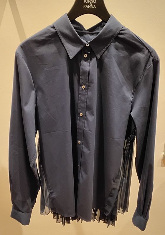 Dunkelblaues Button-Down-Hemd mit plissiertem, transparentem schwarzem Rückenteil. Auf einem schwarzen Kleiderbügel aufgehängt.