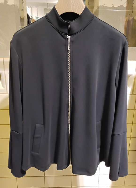 Marineblaue Jacke mit silbernem Reißverschluss, hohem Kragen und ausgestellten Ärmeln.