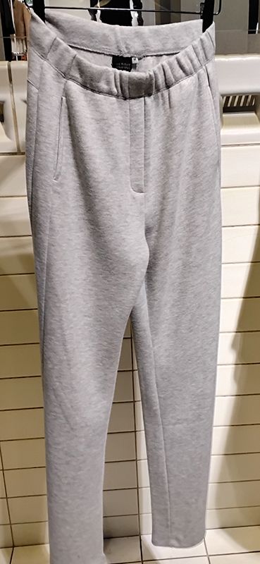 Graue Jogginghosen hängen an einem Kleiderständer.