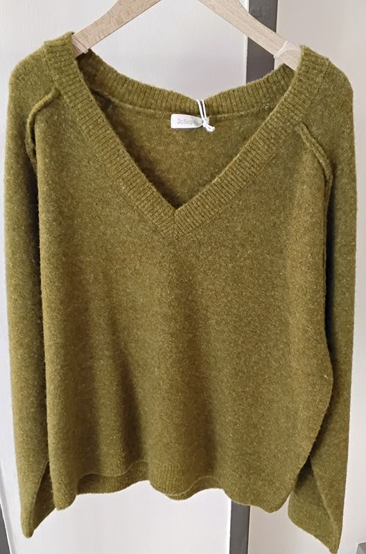 Olivgrüner Pullover mit V-Ausschnitt auf einem Kleiderbügel vor weißem Hintergrund.