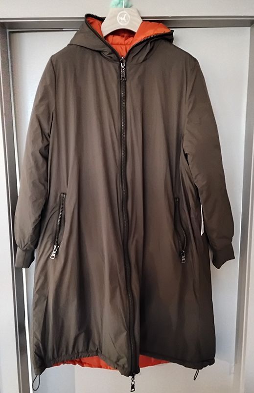 Olivgrüner und orangefarbener Wendbarer Wintermantel mit Kapuze vor weißem Hintergrund.