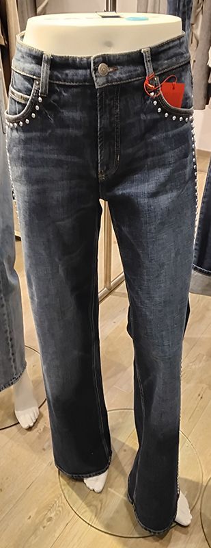 Dunkelblaue Jeans mit Ziernieten und einem roten Herz auf einer Schaufensterpuppe.